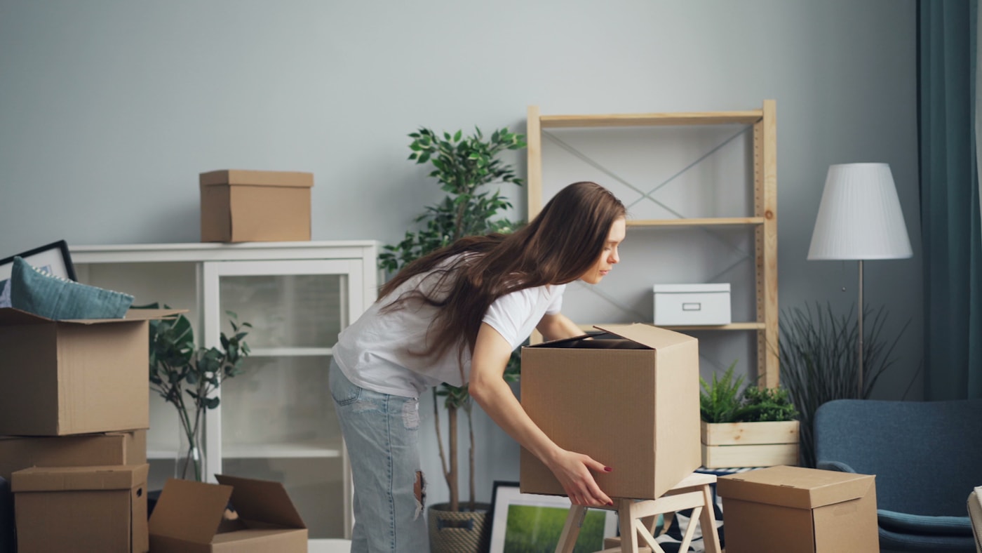 A customer unpacking boxes in a bright new home after a California Loyal Movers move